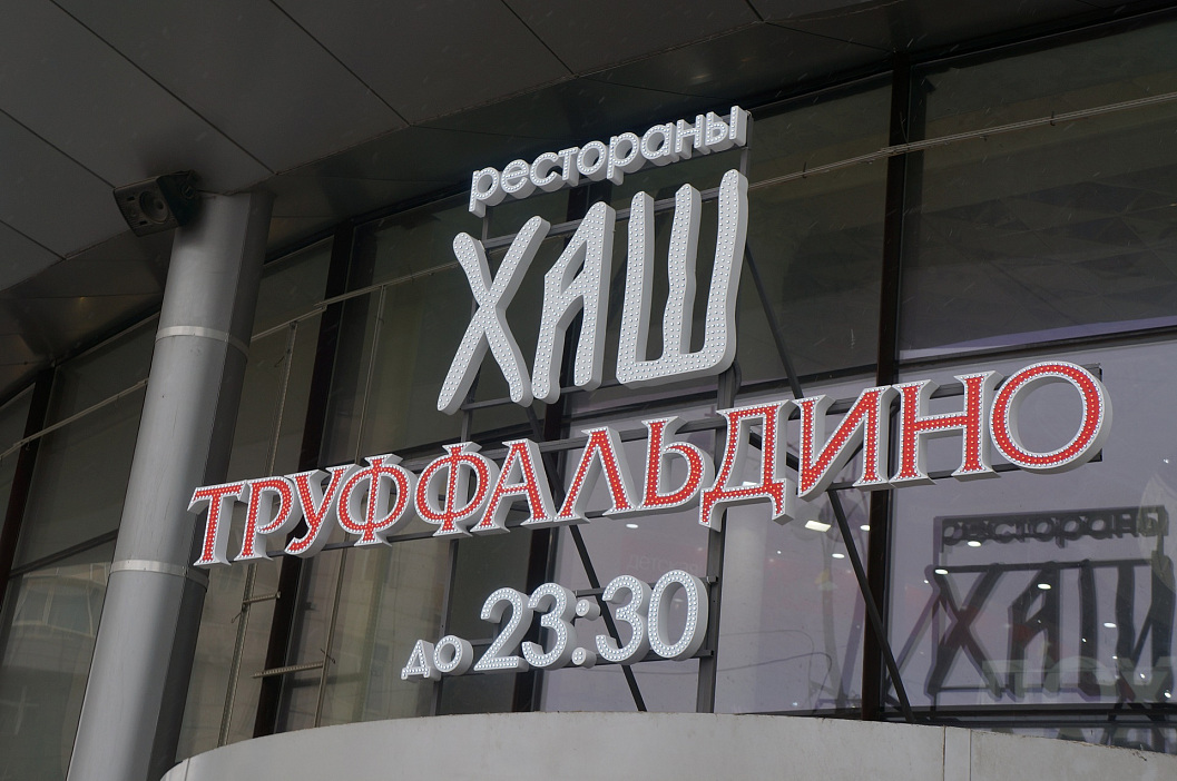 Facade sign in the form of three-dimensional letters illuminated by LED pixels of the Truffaldino and Khash restaurants